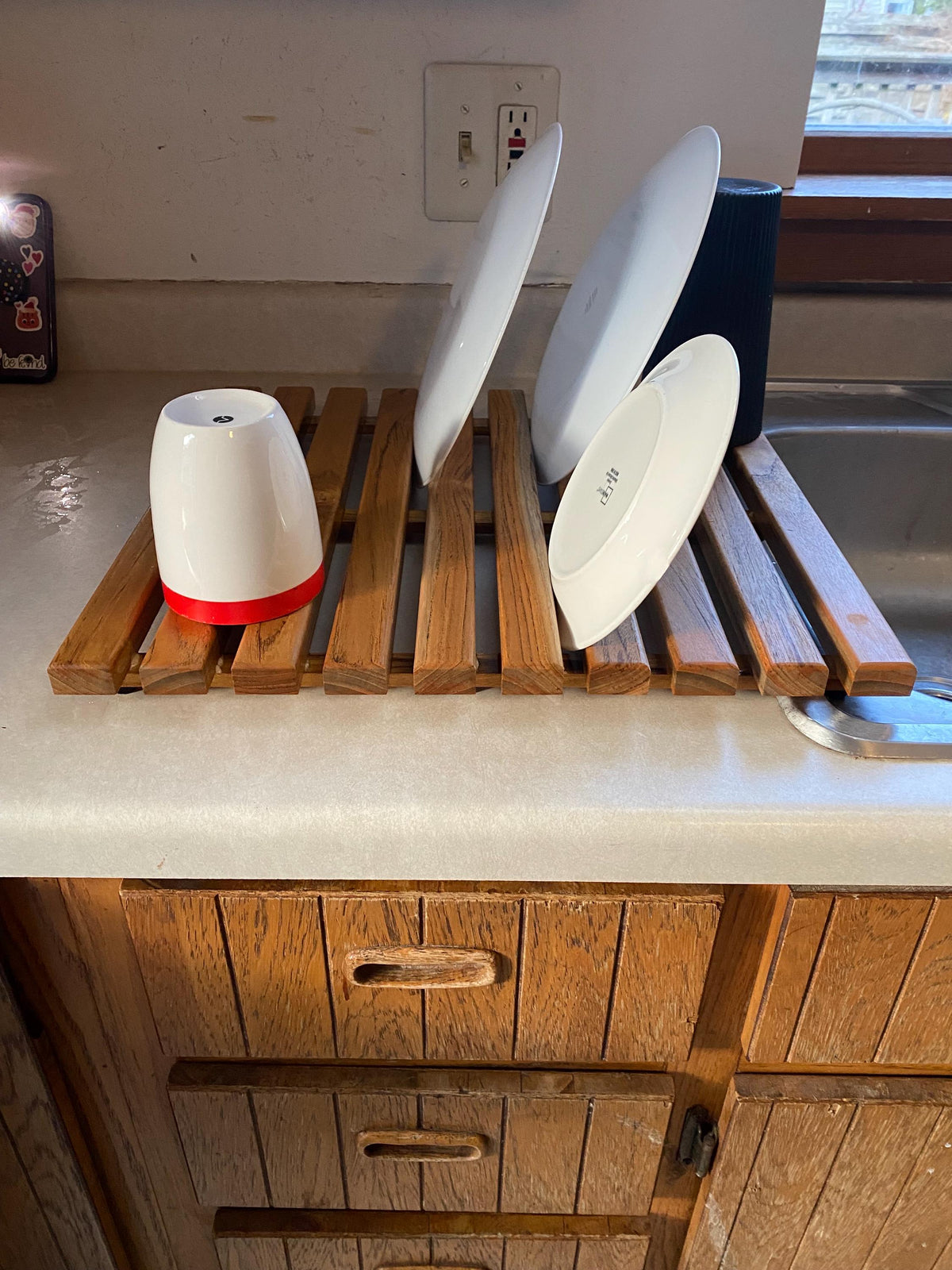Teak dish drying rack holding plates and cups