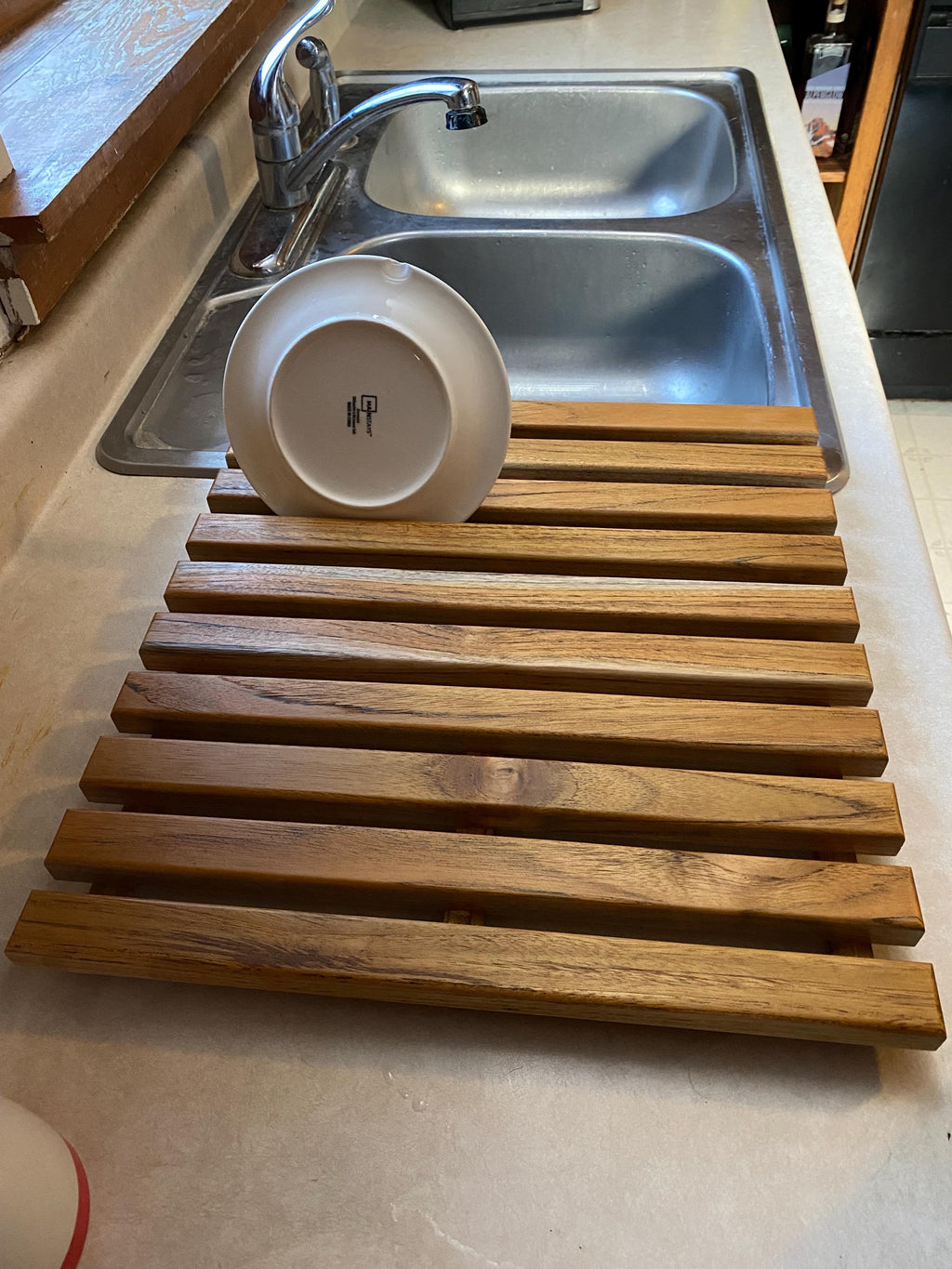 Teak dish drying rack holding a plate