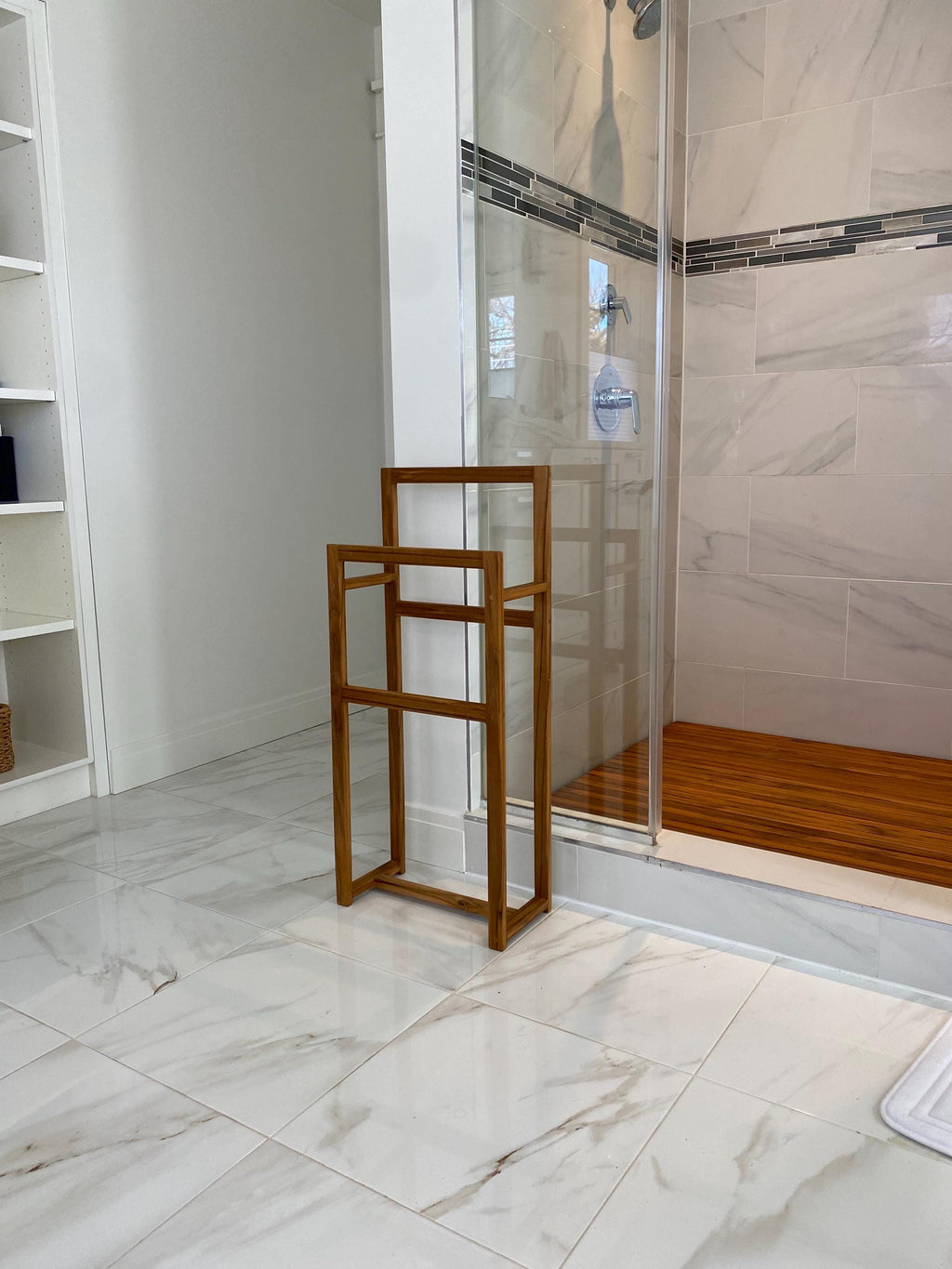 Solid teak towel rack mounted on a bathroom wall far away