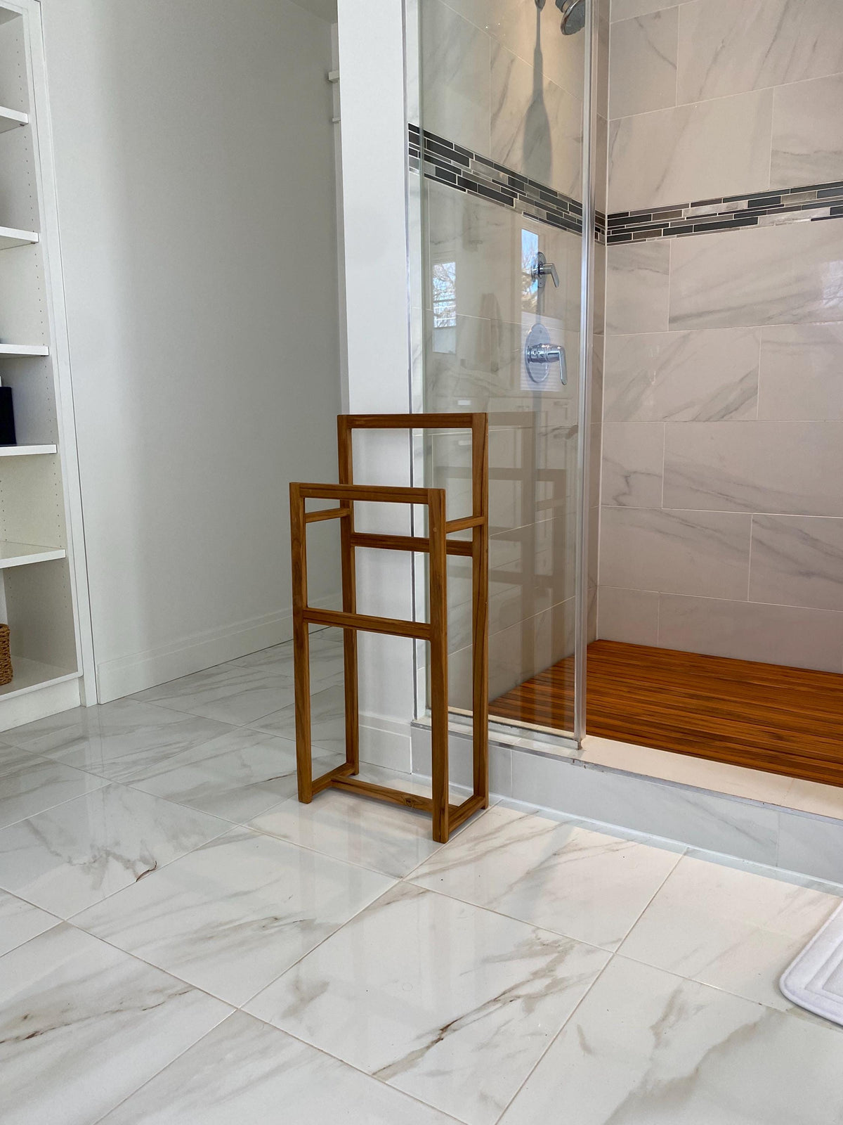Solid teak towel rack mounted on a bathroom wall far away