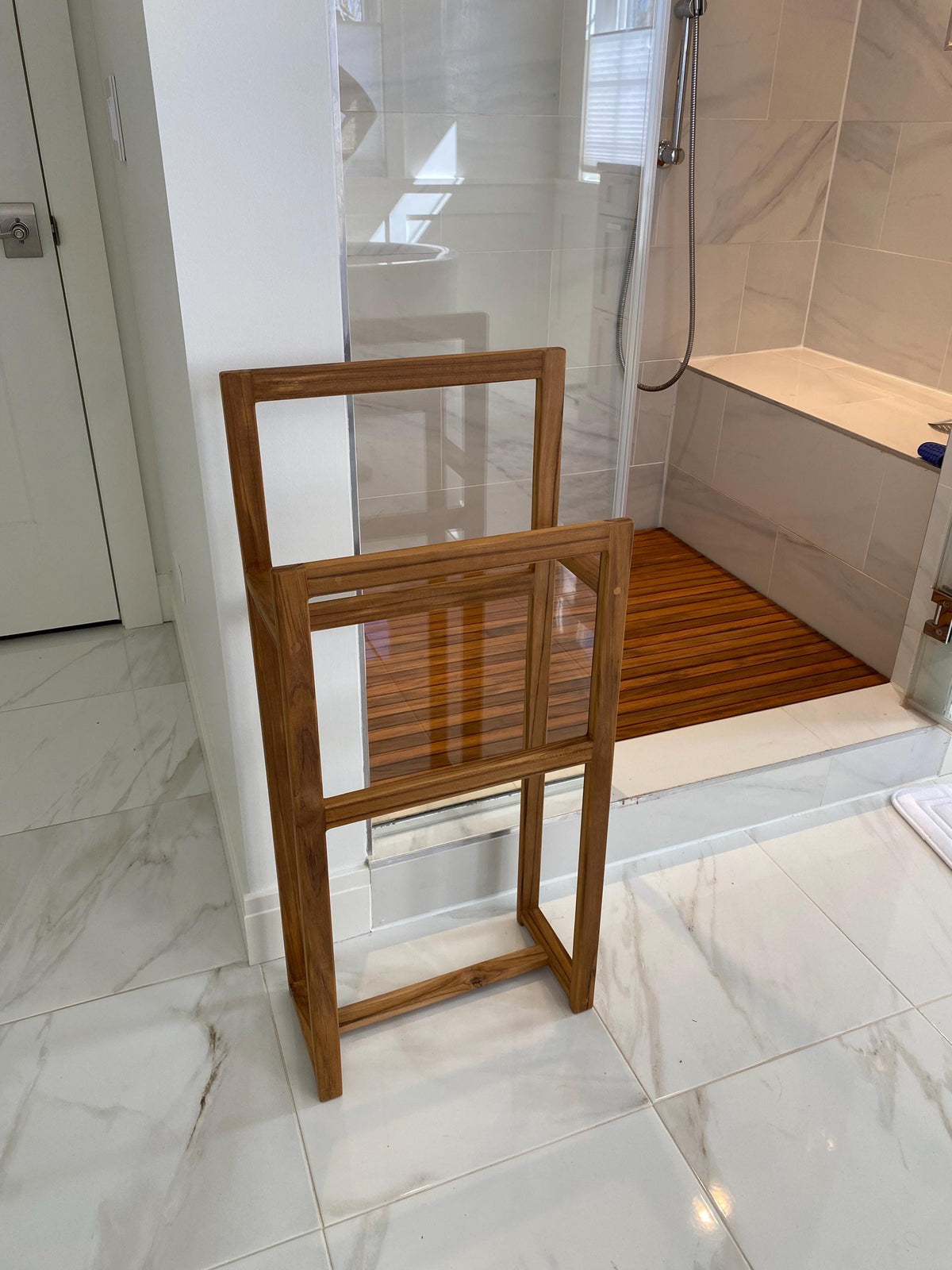 Solid teak towel rack mounted on a bathroom wall closeup