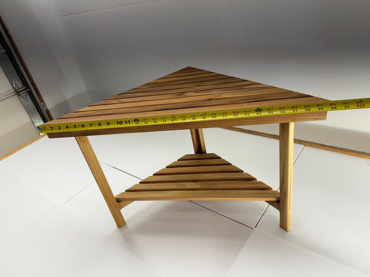 Teak corner bench built into a bathroom shower with tape measure showing width of 30 inches