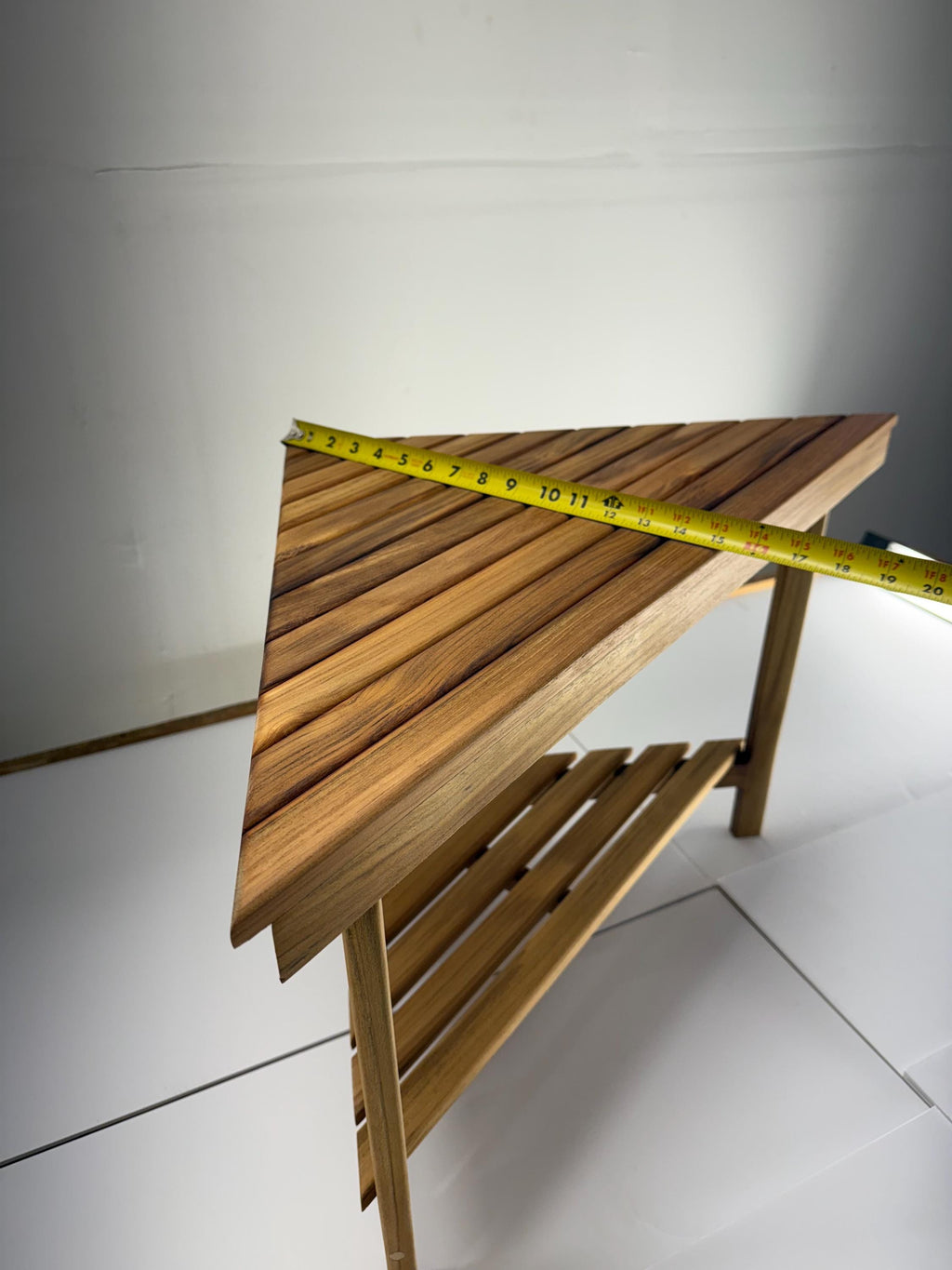 Teak corner bench built into a bathroom shower showing depth of 15 inches