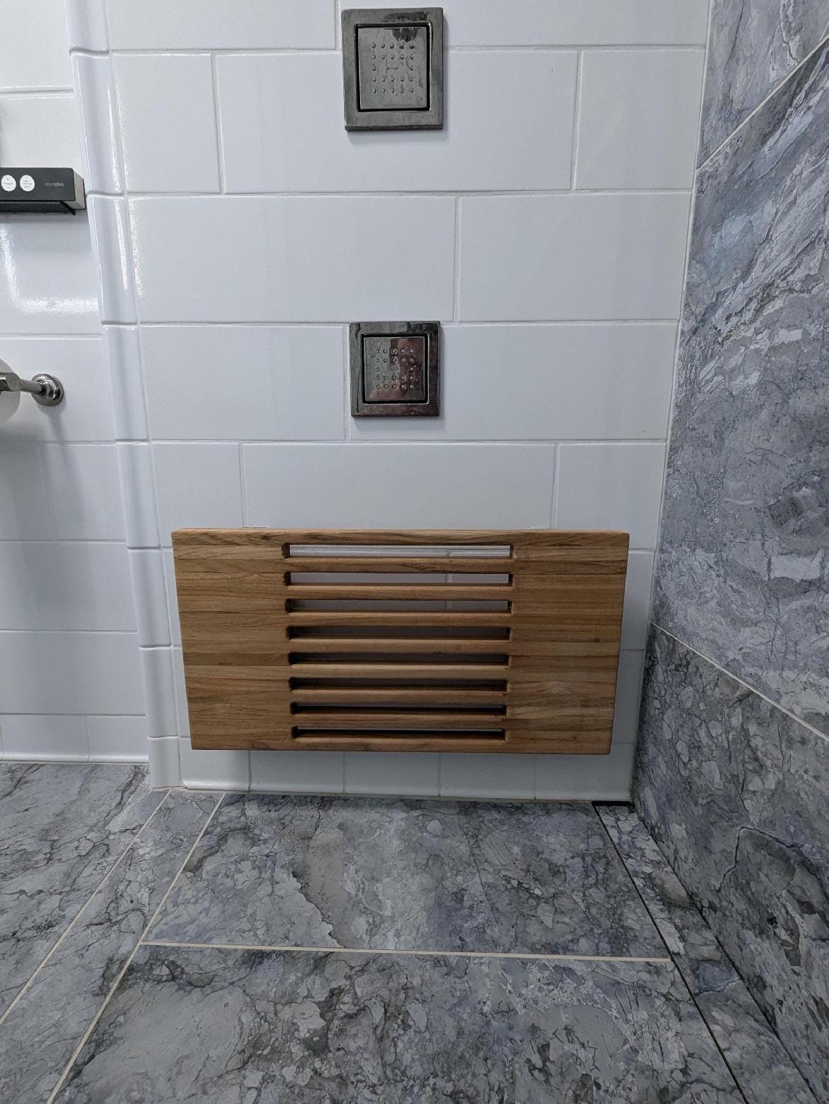 Slatted teak wall-mount bench with drainage gaps between boards folded up