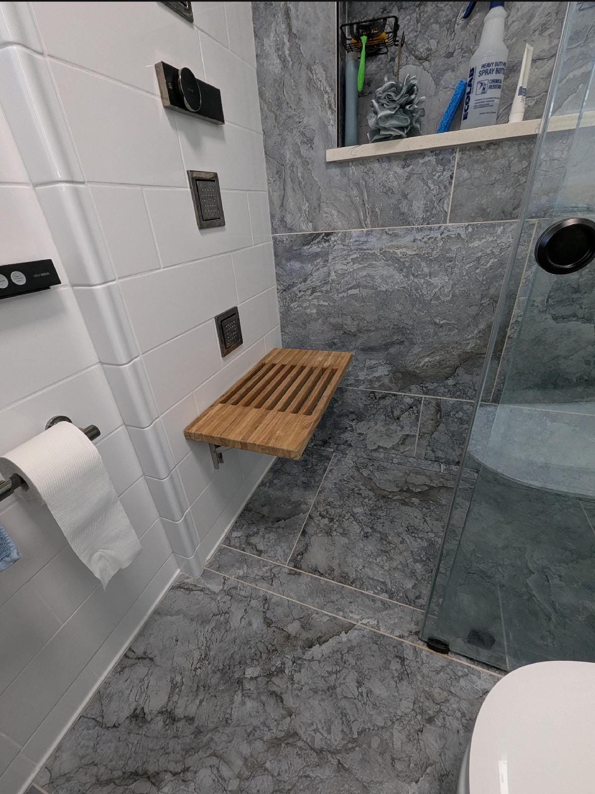 Slatted teak wall-mount bench with drainage gaps between boards