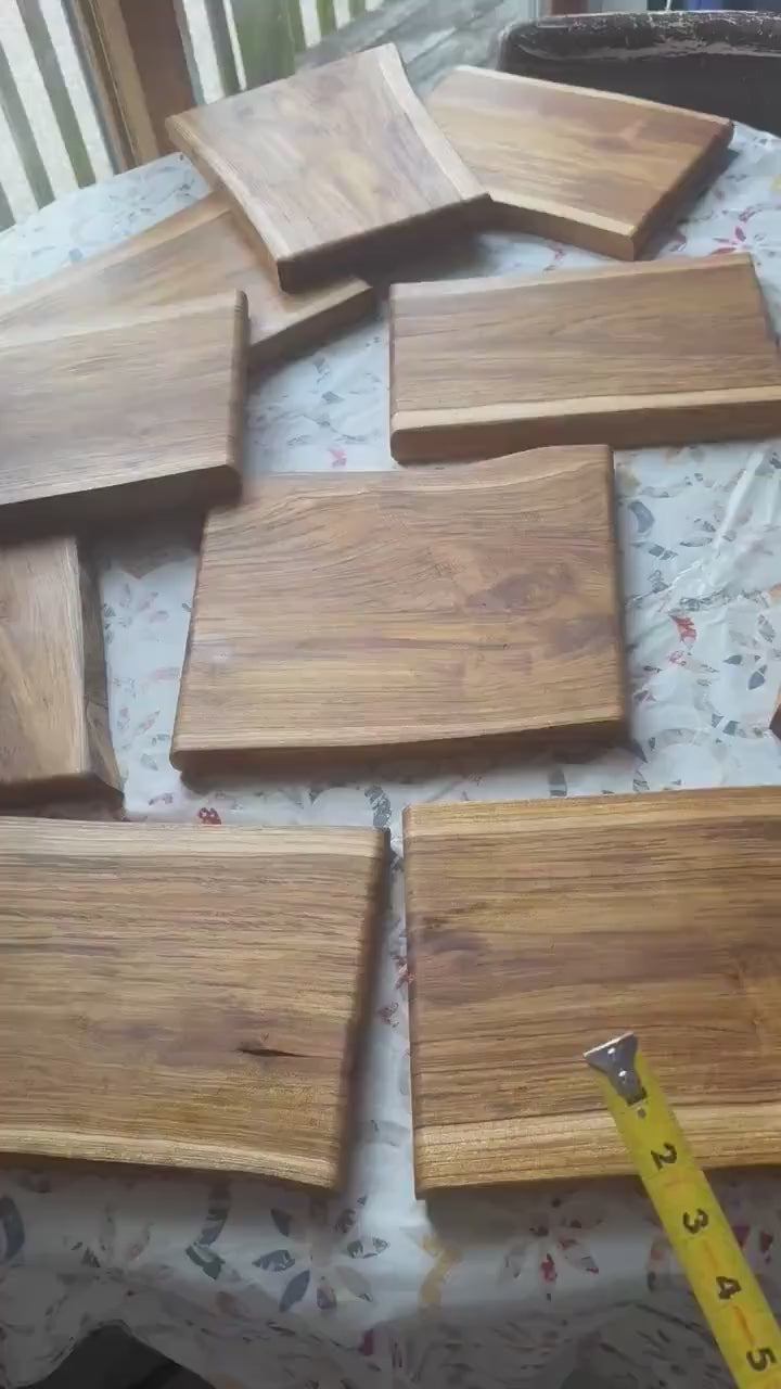 Live-edge teak charcuterie boards with natural wood grain sitting on table